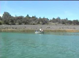 Small boat near shore with people fishing