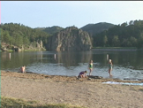 Kids playing on the shore of mountain lake