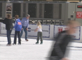 man and little girl ice skating in outside rink