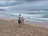 two guys going out to surf  on the north shore in hawaii