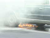 smokey car fire being put out by fire men